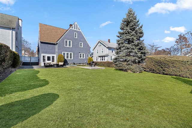 rear view of house featuring a patio and a yard