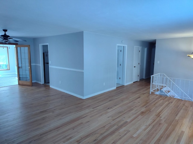 spare room with a ceiling fan, baseboards, and wood finished floors