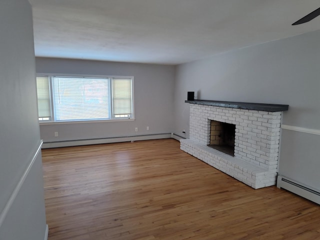 unfurnished living room with a baseboard heating unit, a brick fireplace, and wood finished floors