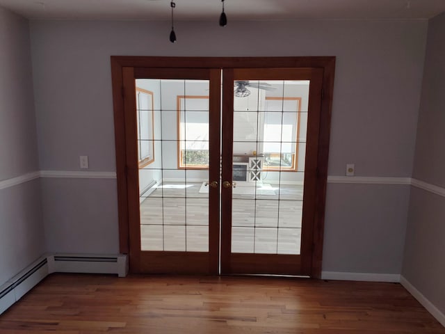 doorway to outside with a baseboard heating unit, french doors, wood finished floors, and baseboards