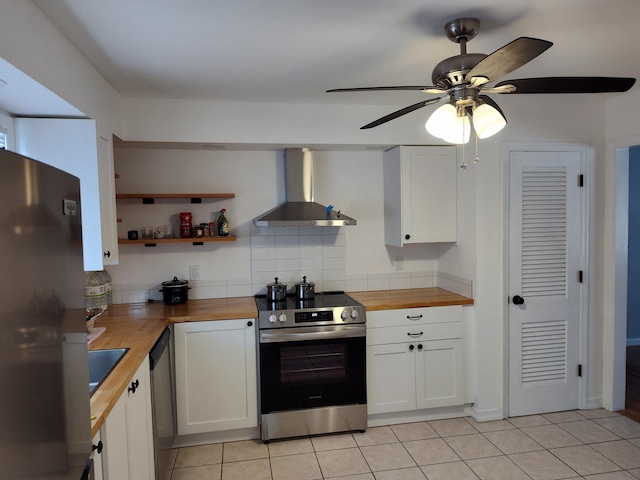 kitchen with white cabinets, wall chimney exhaust hood, appliances with stainless steel finishes, and wooden counters