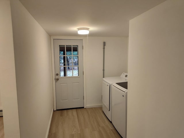 laundry area with laundry area, baseboards, light wood-style flooring, and washing machine and clothes dryer