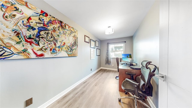 home office with baseboards and wood finished floors