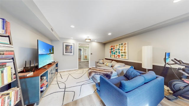 living area featuring light wood-style floors, recessed lighting, visible vents, and baseboards