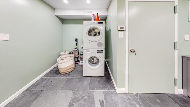 laundry area featuring stacked washing maching and dryer, visible vents, laundry area, and baseboards