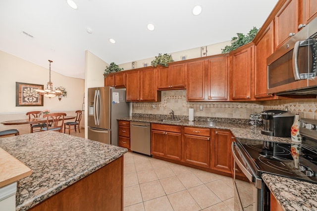 kitchen featuring visible vents, a sink, stainless steel appliances, brown cabinetry, and lofted ceiling