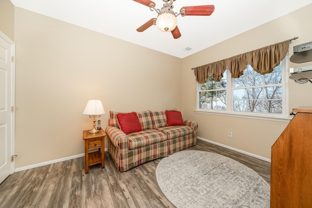 interior space featuring ceiling fan, baseboards, and wood finished floors