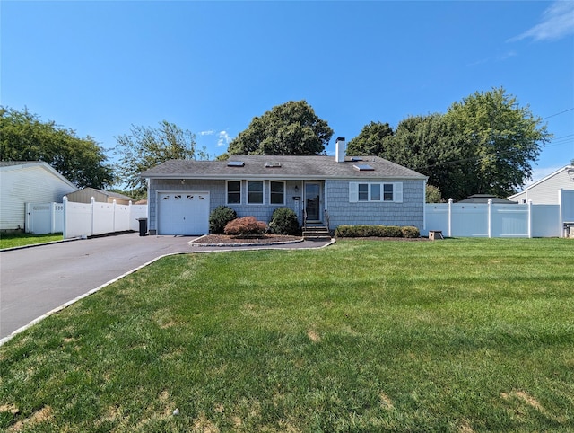 single story home with an attached garage, a front lawn, fence, a chimney, and driveway