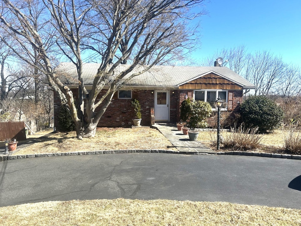 ranch-style house featuring fence and brick siding