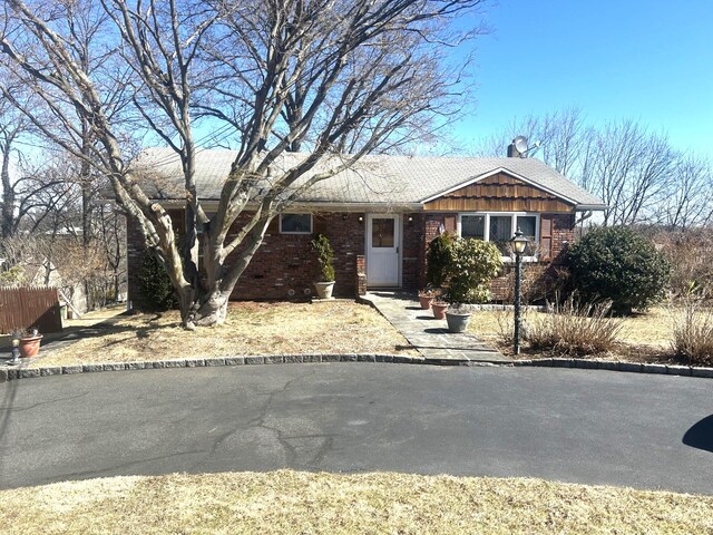 ranch-style house featuring fence and brick siding