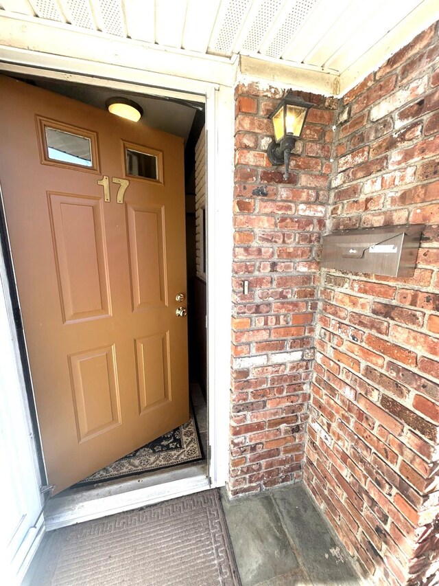 doorway to property featuring brick siding