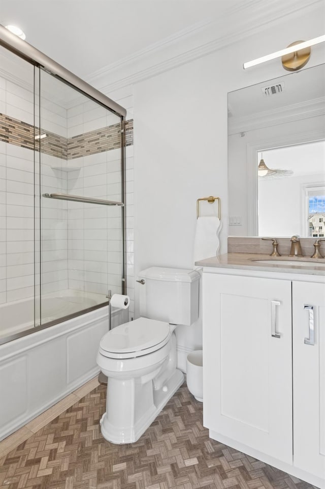 bathroom with ornamental molding, enclosed tub / shower combo, vanity, and toilet