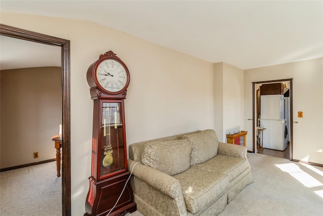 sitting room featuring vaulted ceiling, carpet, and baseboards