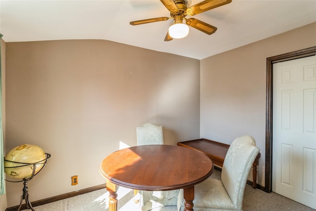 dining area with vaulted ceiling, ceiling fan, baseboards, and light colored carpet