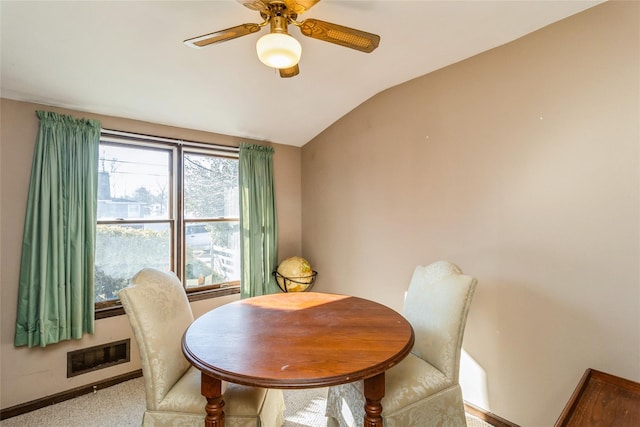 carpeted dining room with vaulted ceiling, ceiling fan, visible vents, and baseboards