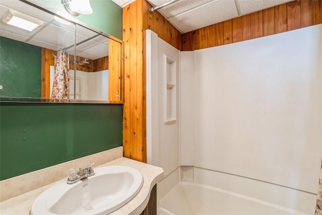 full bath with a drop ceiling, vanity, and shower / tub combo with curtain