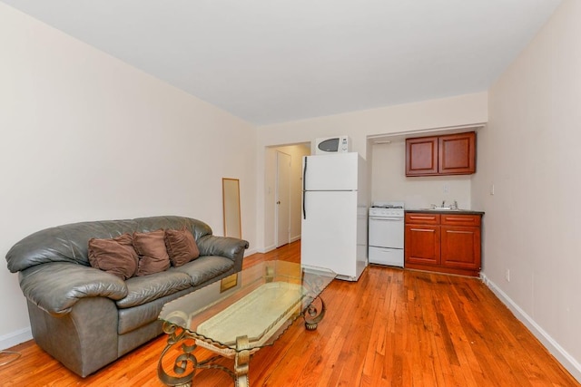 living area featuring light wood-style flooring and baseboards