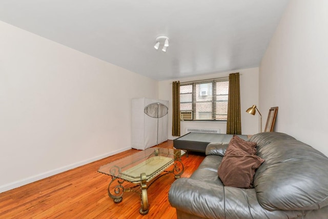 living room with baseboards, radiator heating unit, and wood finished floors