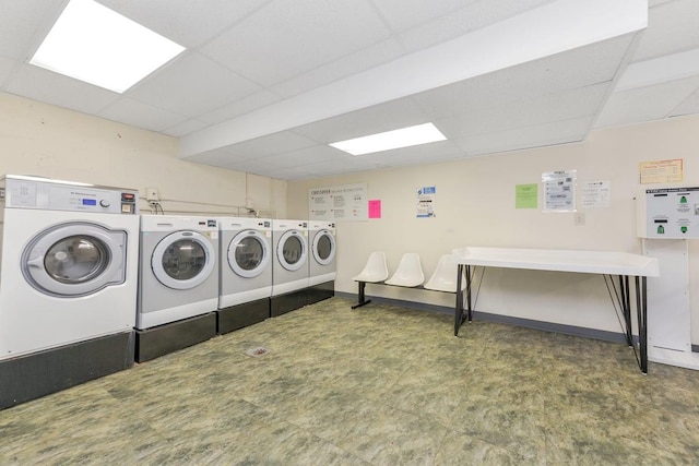 community laundry room featuring baseboards, washer and clothes dryer, and tile patterned floors