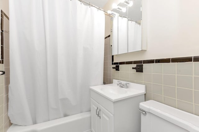 full bathroom featuring toilet, vanity, shower / bath combo with shower curtain, and tile walls