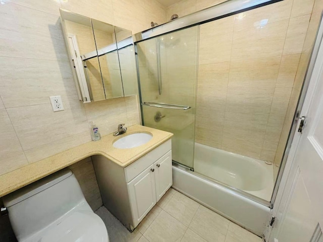 bathroom featuring shower / bath combination with glass door, backsplash, toilet, vanity, and tile patterned flooring