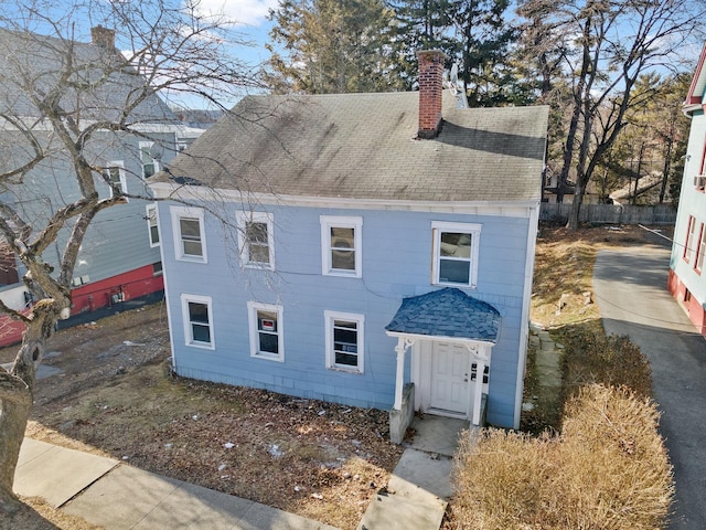 view of front of property with a shingled roof and a chimney