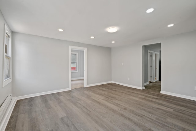unfurnished room featuring recessed lighting, dark wood-style flooring, baseboards, and baseboard heating