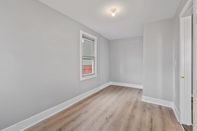 spare room featuring light wood finished floors and baseboards