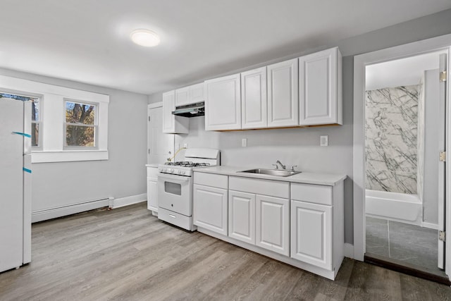 kitchen with white gas stove, a baseboard radiator, under cabinet range hood, a sink, and light countertops