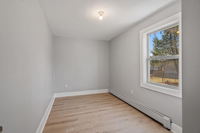 interior space with light wood-type flooring, a baseboard radiator, and baseboards