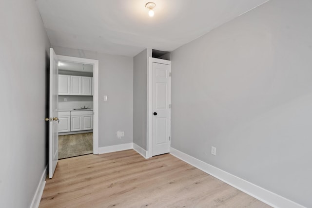 unfurnished bedroom featuring light wood-style flooring and baseboards