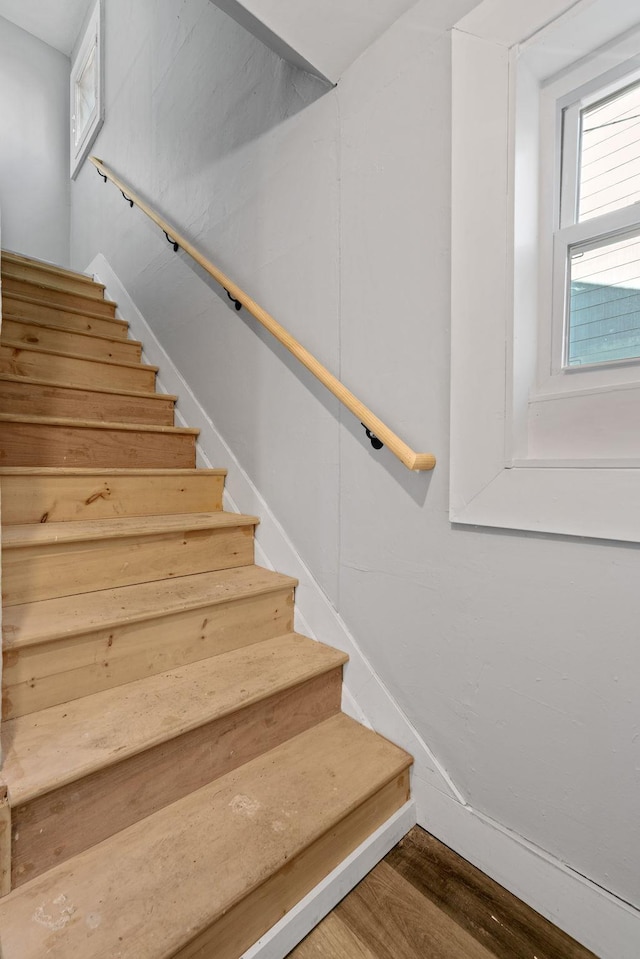 stairway featuring baseboards and wood finished floors
