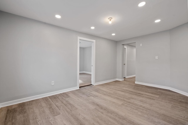 spare room featuring recessed lighting, baseboards, and wood finished floors