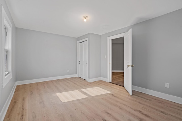 unfurnished bedroom with baseboards and wood finished floors