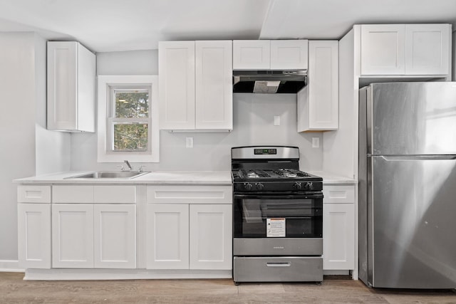 kitchen featuring appliances with stainless steel finishes, white cabinets, a sink, and under cabinet range hood