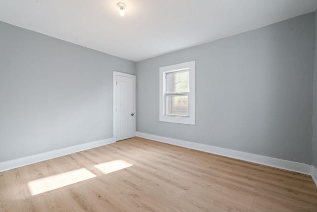 unfurnished room featuring baseboards and wood finished floors