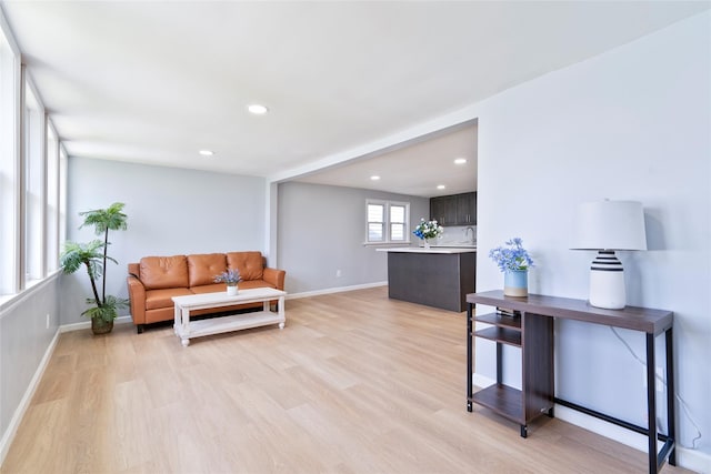 living room featuring light wood-style floors, baseboards, and recessed lighting