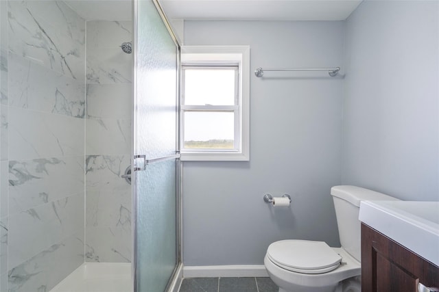 bathroom featuring toilet, vanity, baseboards, tile patterned floors, and a stall shower