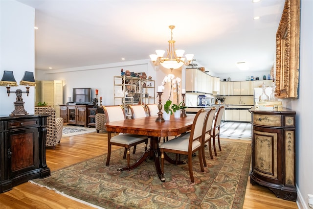 dining space with recessed lighting, light wood-type flooring, a chandelier, and vaulted ceiling