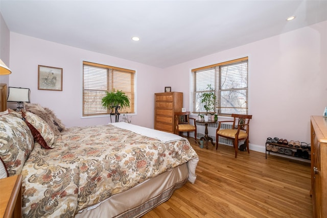 bedroom featuring radiator heating unit, recessed lighting, baseboards, and light wood finished floors