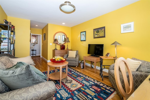 living area with recessed lighting, baseboards, and wood finished floors