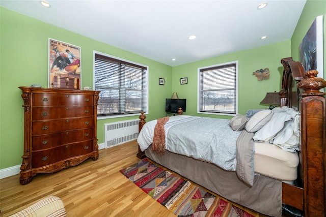 bedroom featuring recessed lighting, radiator heating unit, baseboards, and wood finished floors