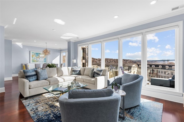 living room with visible vents, crown molding, baseboards, and wood finished floors