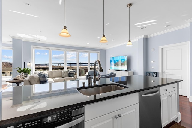 kitchen featuring dark countertops, ornamental molding, open floor plan, and a sink