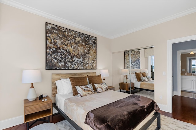 bedroom featuring baseboards, wood finished floors, a closet, and ornamental molding