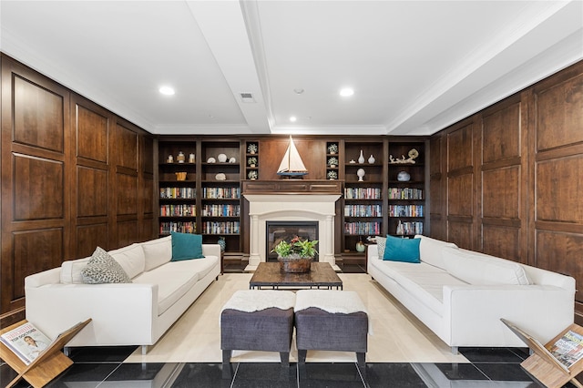 living room with built in features, visible vents, wooden walls, and a glass covered fireplace