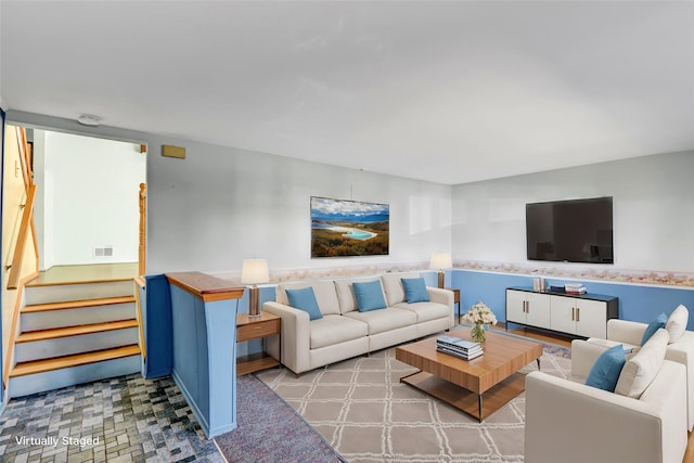 living room featuring visible vents and stairs