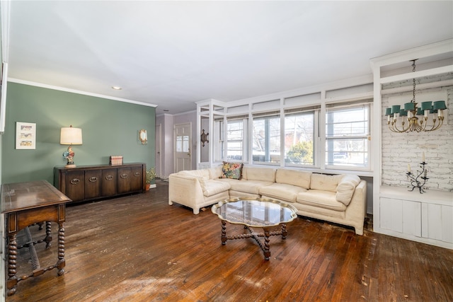 living area with ornamental molding, hardwood / wood-style floors, and an inviting chandelier