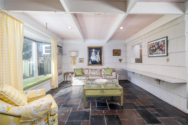 living area featuring beamed ceiling, stone tile flooring, and recessed lighting