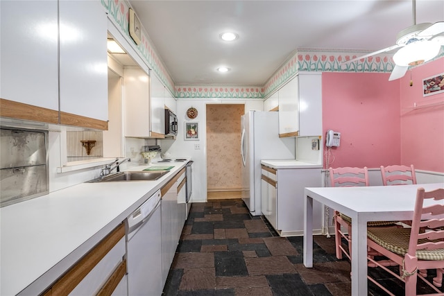 kitchen with white appliances, light countertops, a sink, and white cabinets